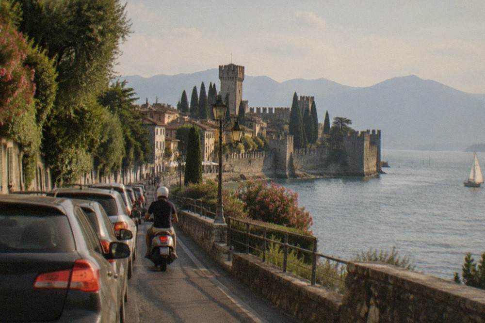 The lakeside road approaching Sirmione with the peninsula stretching into the water ahead