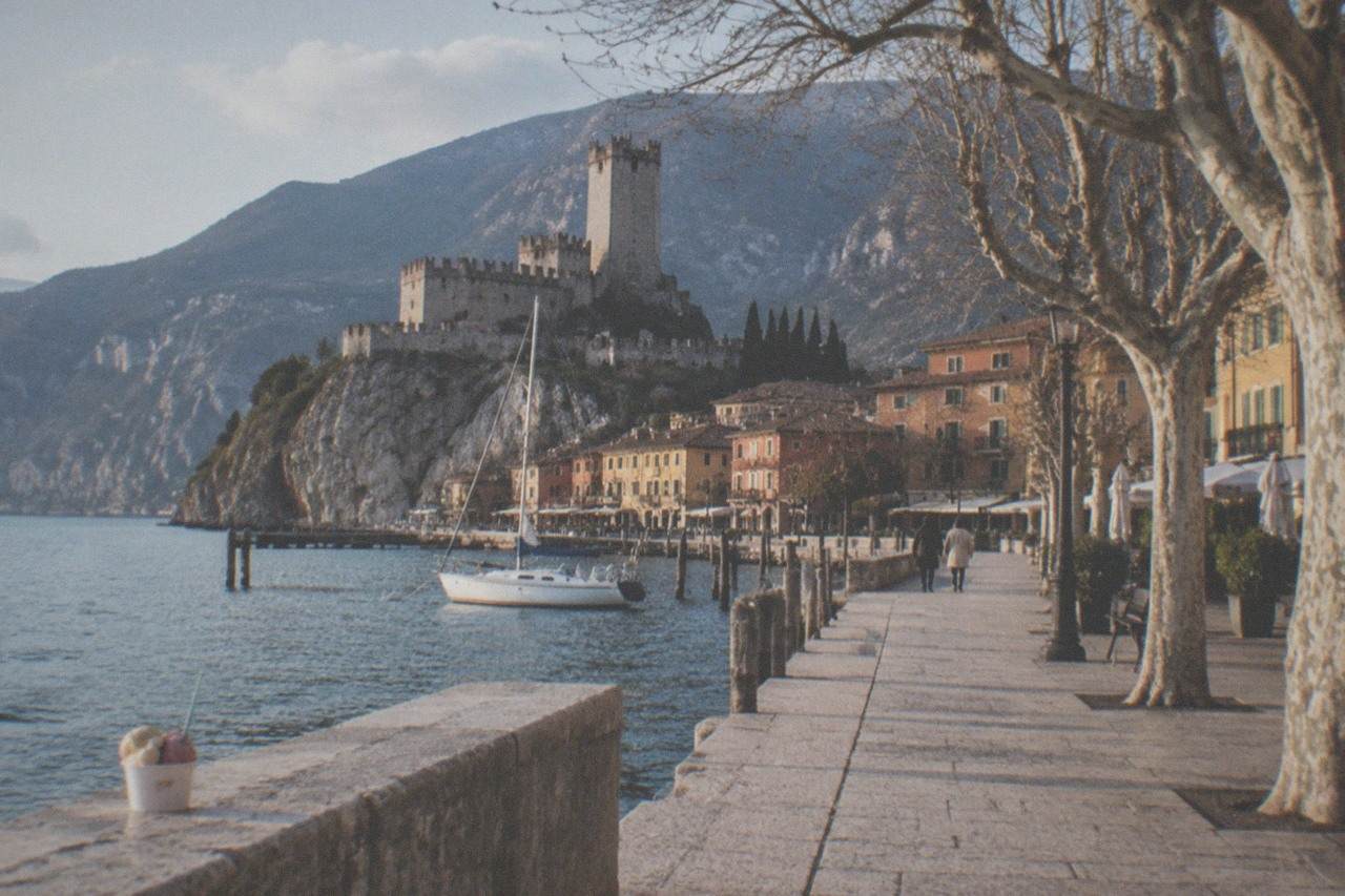 A view of Malcesine's lakeside promenade with the Scaliger castle and Monte Baldo rising behind