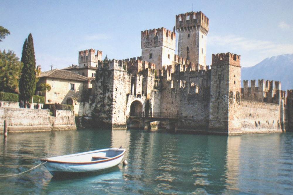 Sirmione peninsula seen from the water with the castle and old town rooftops