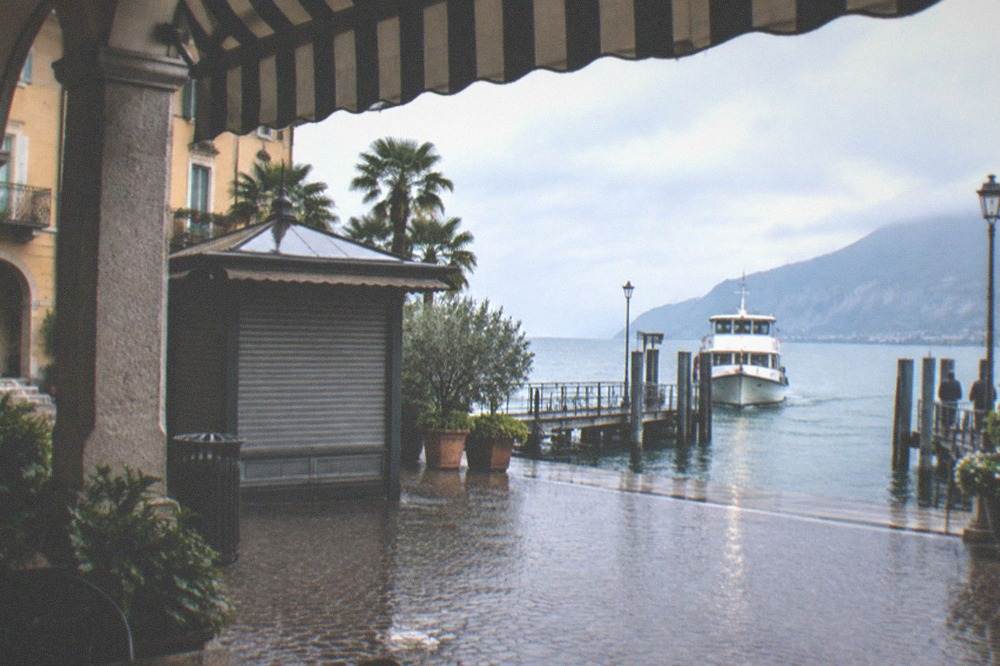 A ferry ticket office beside a landing stage with a passenger boat at the pier