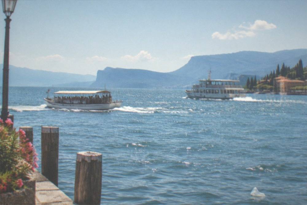 A tour boat and a passenger ferry passing each other on open water at midday