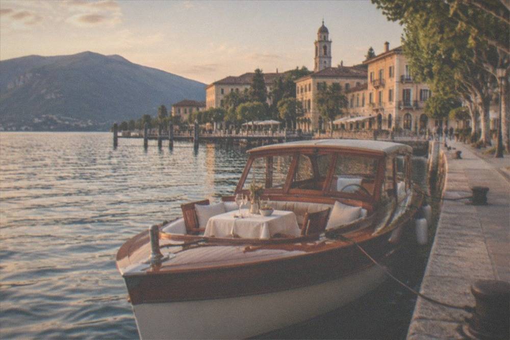 A Belle Époque wooden launch with an aperitif table set on the foredeck, moored in Salò harbour
